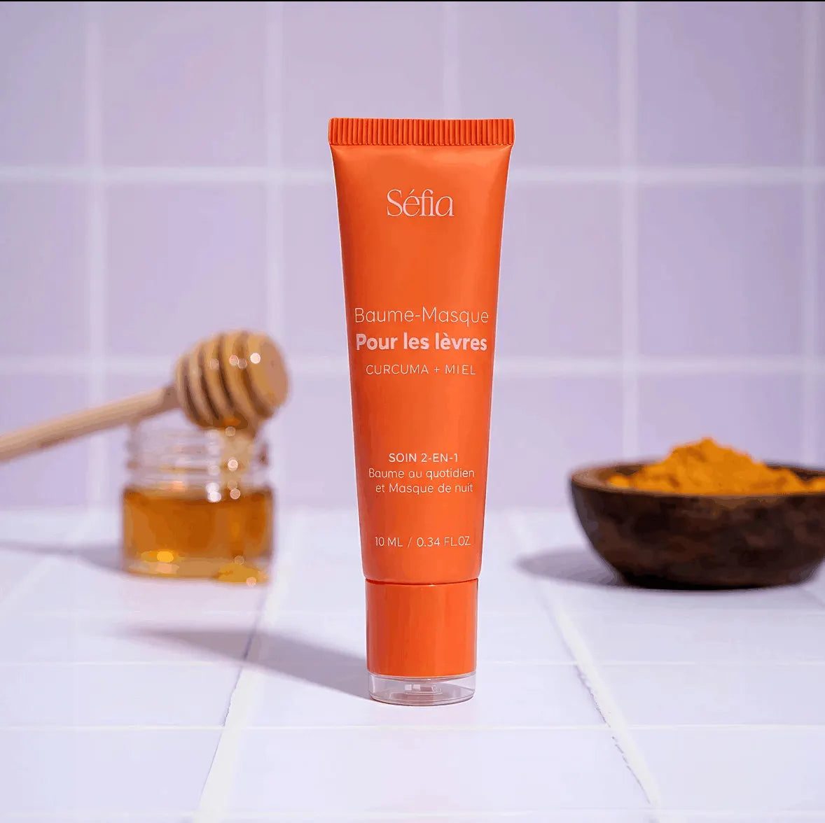 Baume Masque Lèvres Séfia au miel et au curcuma, posé à côté d'un pot de miel et d'une coupelle de curcuma Image